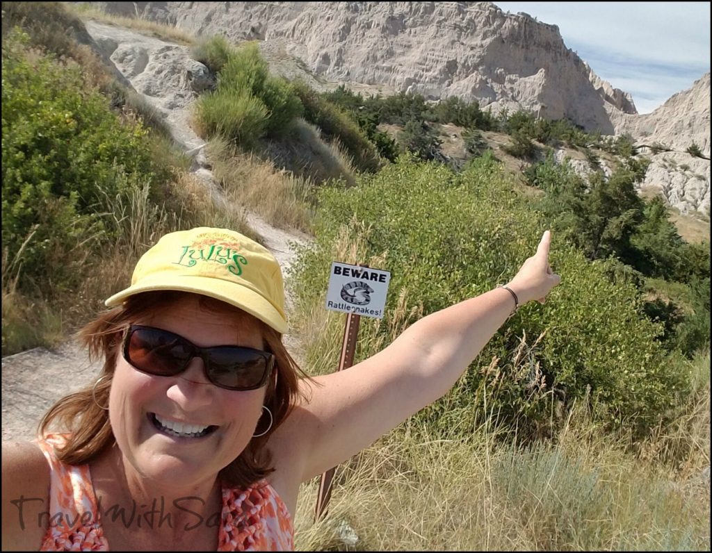 Sara with rattlesnake sign on trail in Badlands National Park