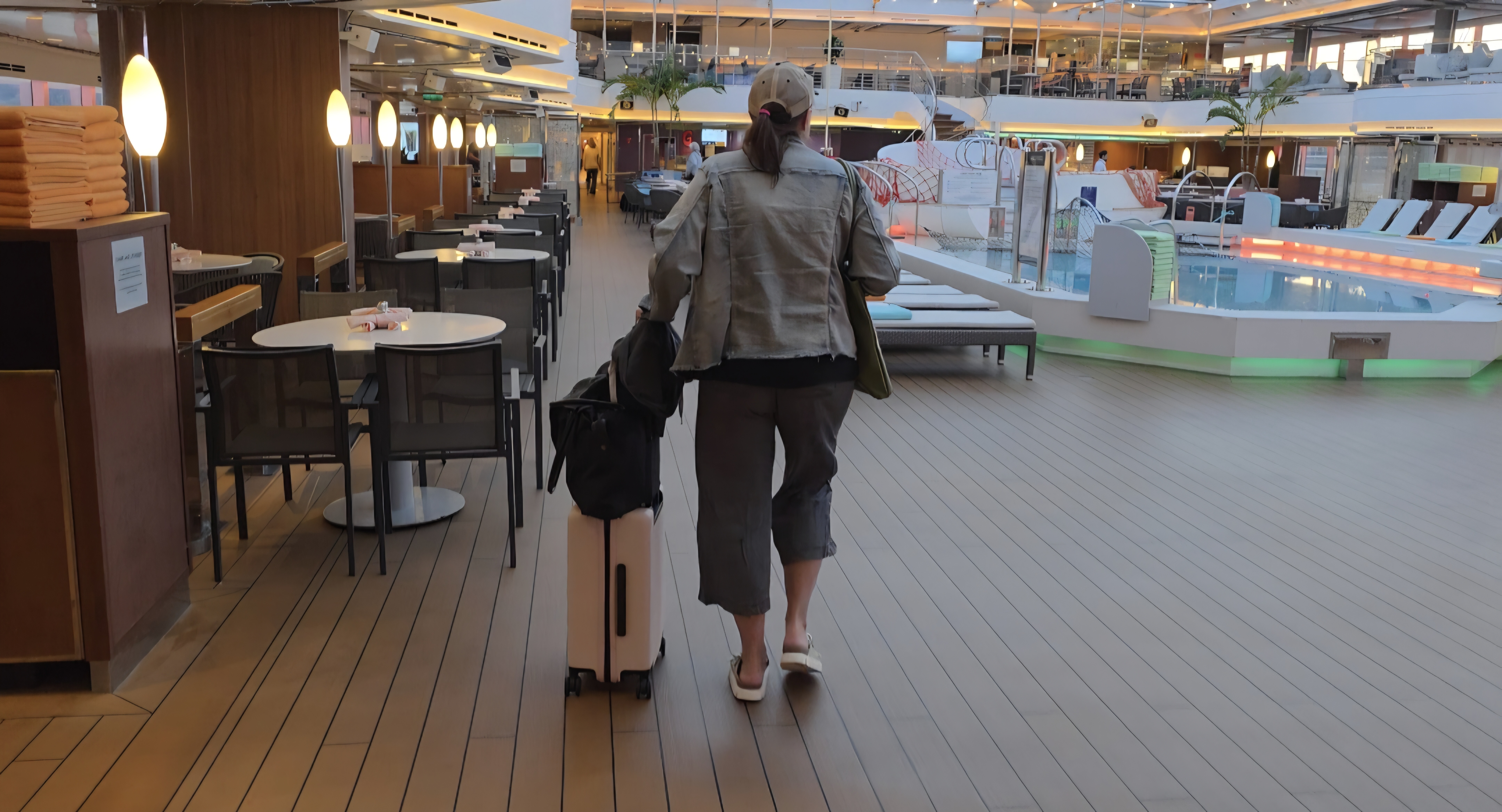 woman with pink suitcase on cruise ship